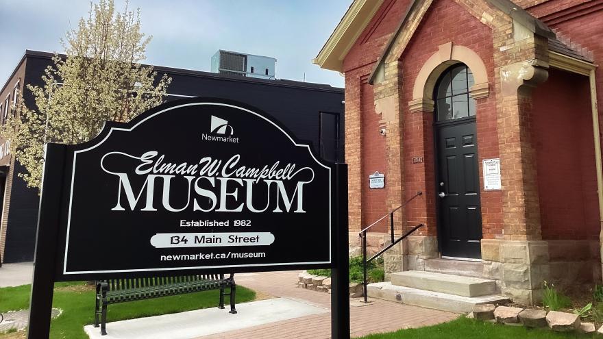 The Elman W. Campbell Museum sign with a historic brick building in the background.