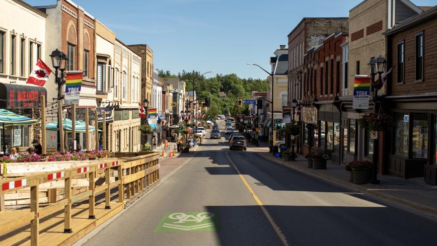 Newmarket main street on a sunny day with shops and people walking