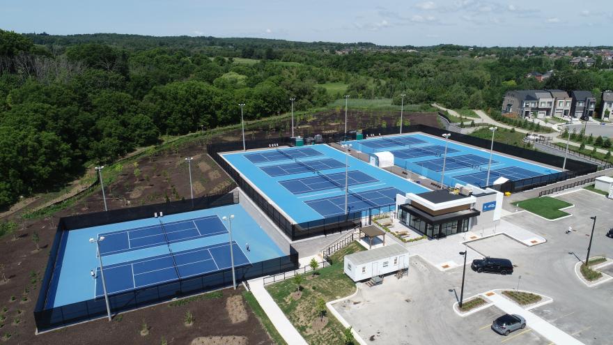 Aerial view of an outdoor tennis facility with multiple courts