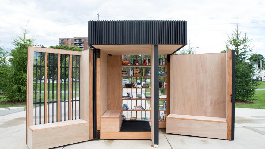 Story Pod with open wooden doors and books on shelves.