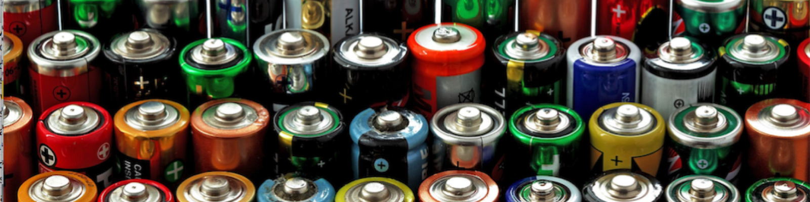 A variety of colorful batteries lined up in rows.