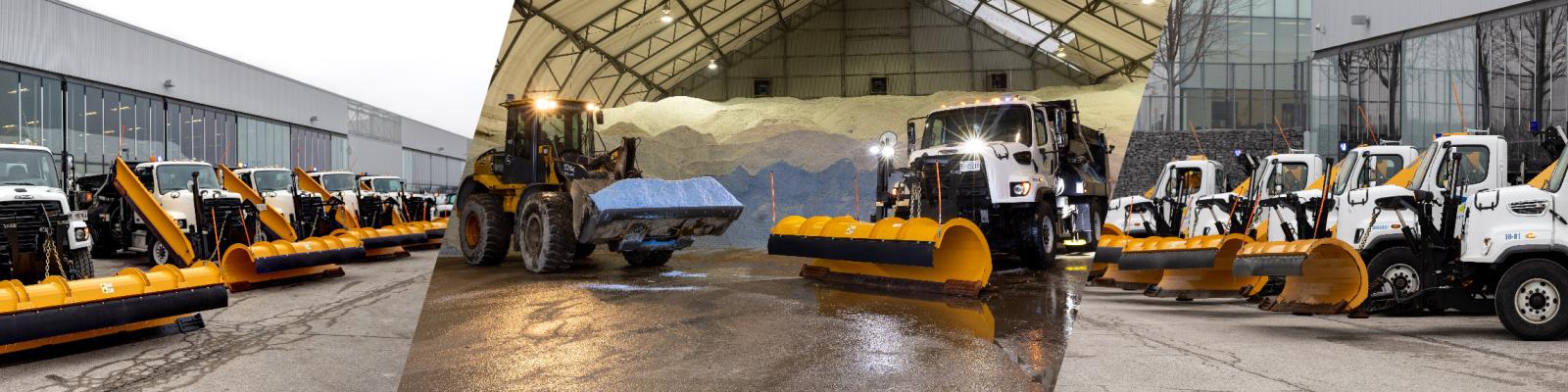 Snowplows and machinery parked in a warehouse and outdoor lot.