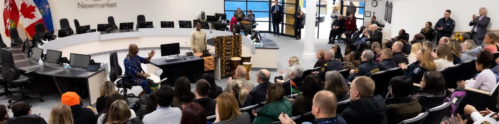 Crown of people in a room with a speaker at a podium