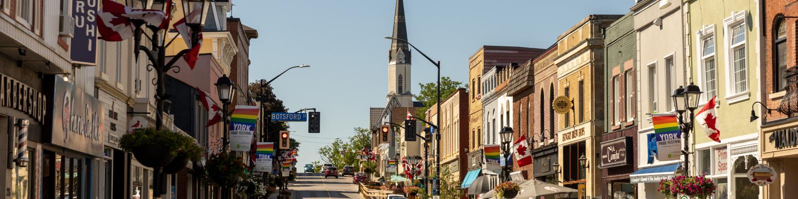 Main Street Newmarket with car driving on road during a sunny day