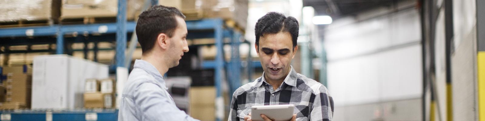 two people chatting about business in a warehouse stock room