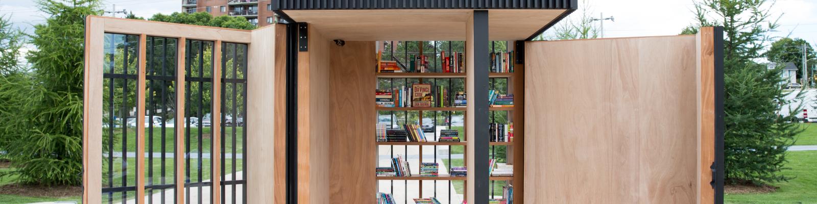 Story Pod with open wooden doors and books on shelves.