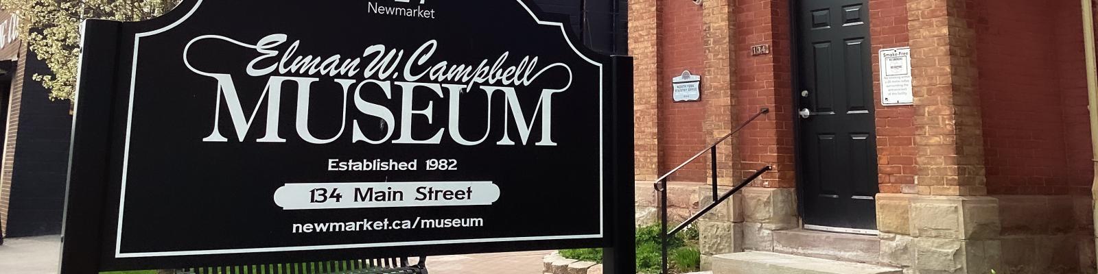 The Elman W. Campbell Museum sign with a historic brick building in the background.