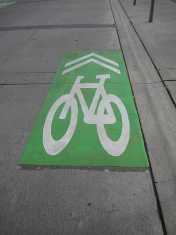 Green bike lane marking on pavement.