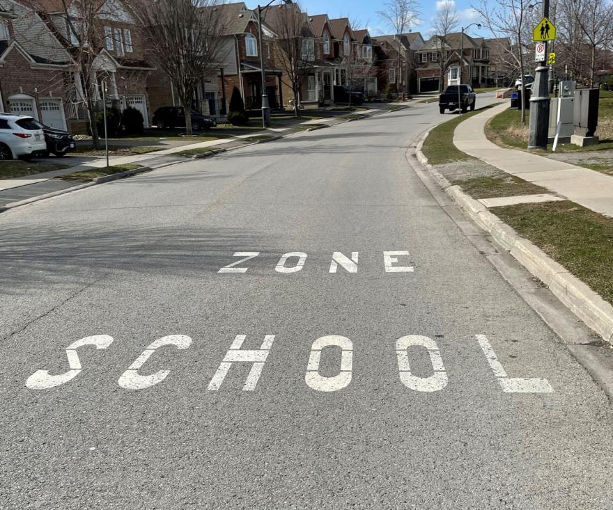 School zone painted on a suburban street.