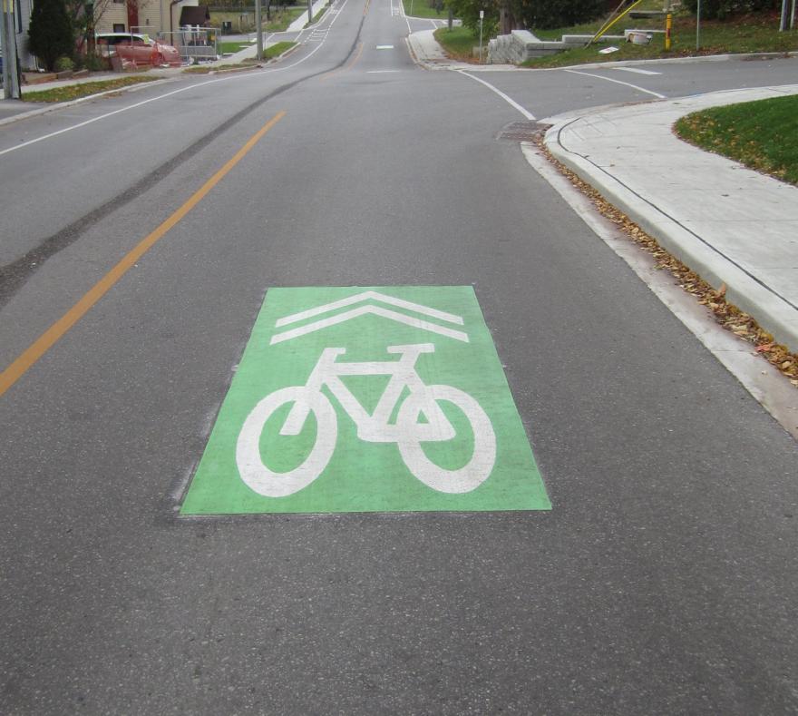 Green bicycle lane symbol on a quiet road.