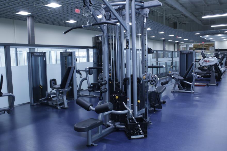 Spacious gym filled with various exercise machines and equipment.