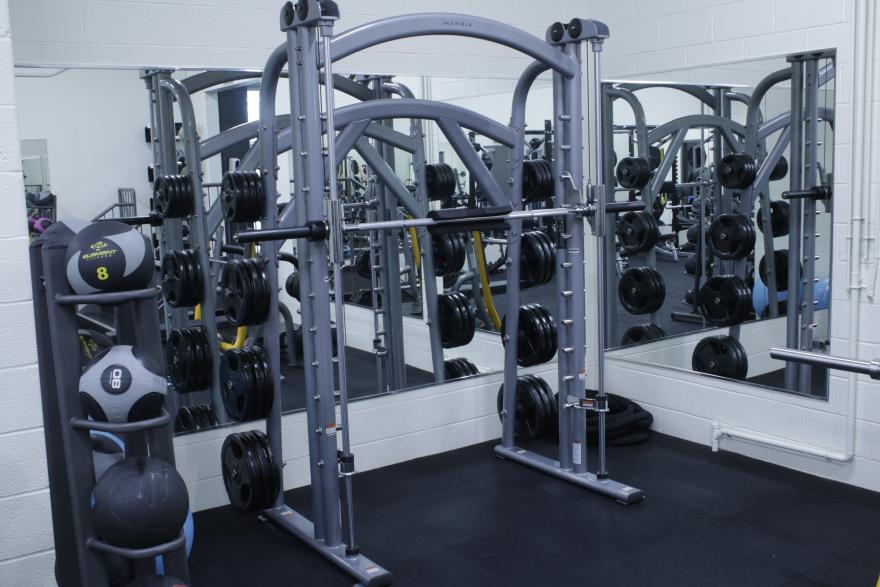 Gym with weightlifting equipment and mirrors.