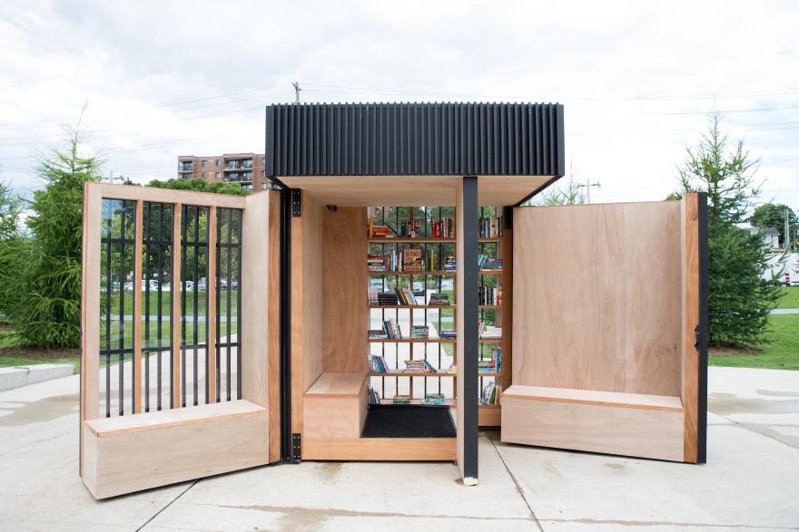 Story Pod with open wooden doors and books on shelves.