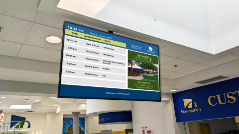Digital display in an office with schedule and park image.