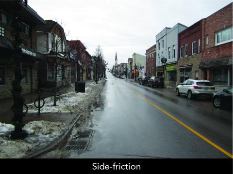 Snowy street lined with shops, overcast sky.