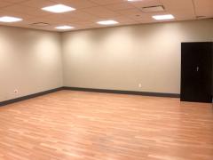 Empty room with wooden floor and beige walls.