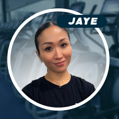 Smiling woman in a gym, with treadmills in the background.