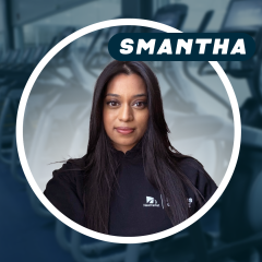 Person with long hair in a gym setting, wearing a black top.