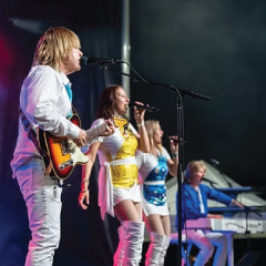 Band performing on stage with vibrant costumes and instruments.