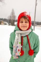 Child wearing winter clothing on a snowy hillside