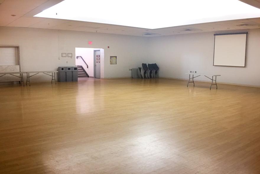Spacious empty room with wooden floor and white walls.