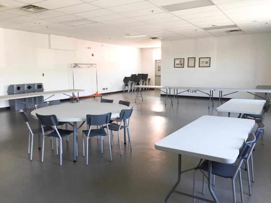Empty conference room with tables and chairs.