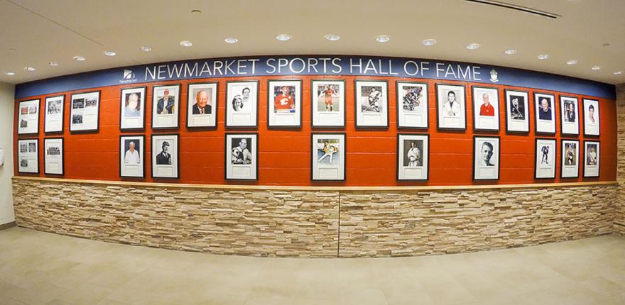 Framed portraits on a wall in a hall of fame display.