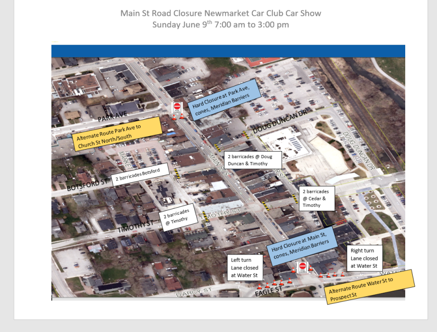 Aerial view of streets with road closure signs for a car show event.