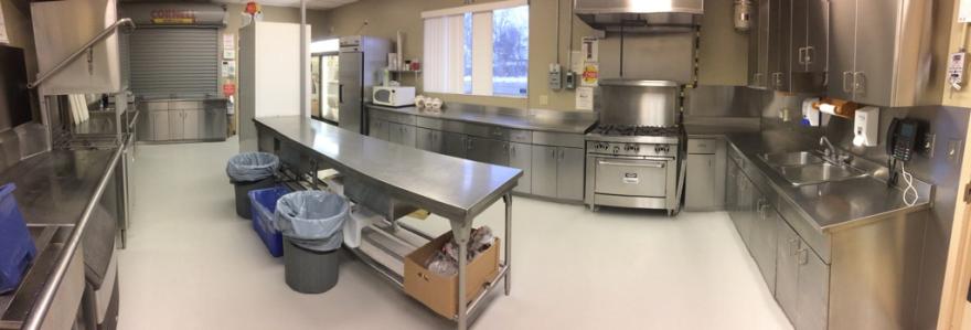 Commercial kitchen with stainless steel appliances and countertops.