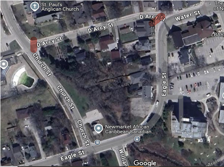 Satellite view of a neighborhood with roads, houses, and trees.