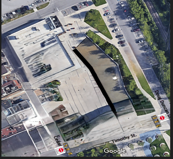 Satellite view of a city block with roads and greenery.