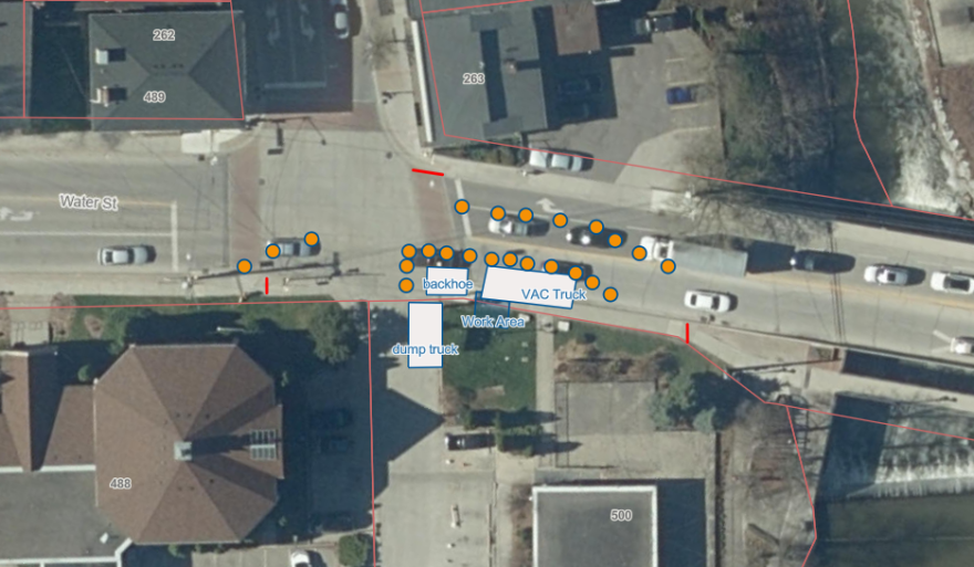 Aerial view of an urban intersection with several cars and buildings.