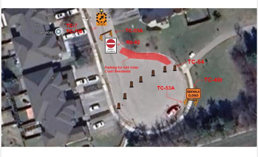 Satellite view showing a parking lot with traffic cones and red route markings.